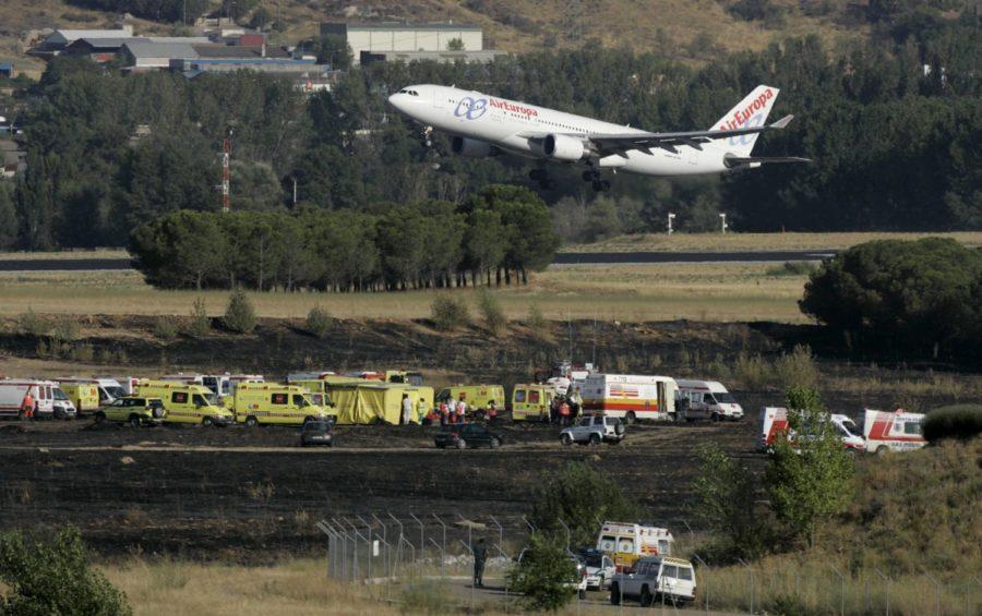 A plane takes off near the site where a Spanair jet crashed on takeoff at Madrid airport on Wednesday, Aug. 20, 2008. A Spanish airliner carrying 173 people bound for the Canary Islands crashed and caught fire Wednesday while trying to take off from Madrids Barajas airport. At least 45 people were killed, the Interior Ministry said. There were fears the death toll could rise, with some Spanish media reporting more than 100 dead. In addition to the 45 confirmed dead, at least 19 were seriously injured and 25 slightly hurt, the Interior Ministrys office for the greater Madrid region said. (AP Photo/Victor R. Caivano)