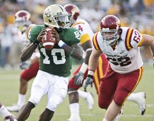 Baylor quarterback Robert Griffin, left, looks down field while being pressured by Iowa States Nate Frere, right the third quarter on Saturday. Baylor handed Iowa State its fourth straight loss, 38-10. Photo: Associated Press/Duane A. Laverty