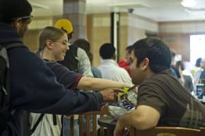 Voters reach for some candy from James Boyle, senior in Forestry, while waiting in line at Ward 2, Precinct 2, Tuesday at Frederiksen Court. Boyle had several bags of candy to keep voters from leaving if the line got too long. Photo: Logan Gaedke/Iowa State Daily