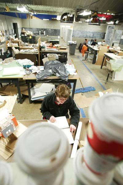 Kathryn Kern, sophomore in construction engineering, packs up her workspace in Studio 81 of the Armory. Long hours spent working on design projects led to several students making trips to coffee shops on campus. The students’ collection of cups adorns the exterior wall of their studio. Photo: Ben Brabant/Iowa State Daily