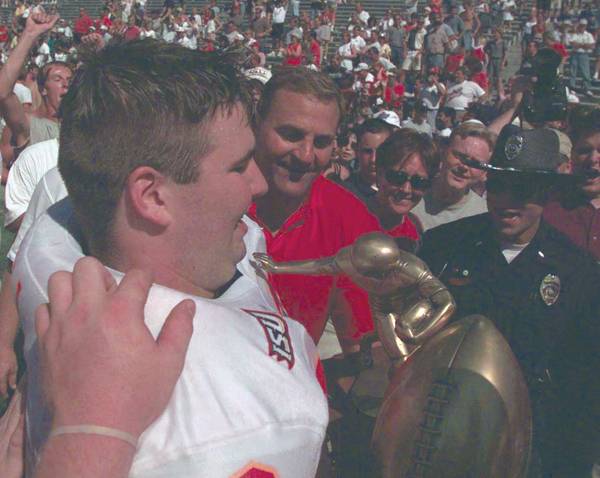 Charlie Bogwell holds the Cy-Hawk trophy as he celebrates their victory over Iowa with coach Dan McCarney. The victory was the Cyclones first over the Hawkeys in 15 years. File Photo: Iowa State Daily