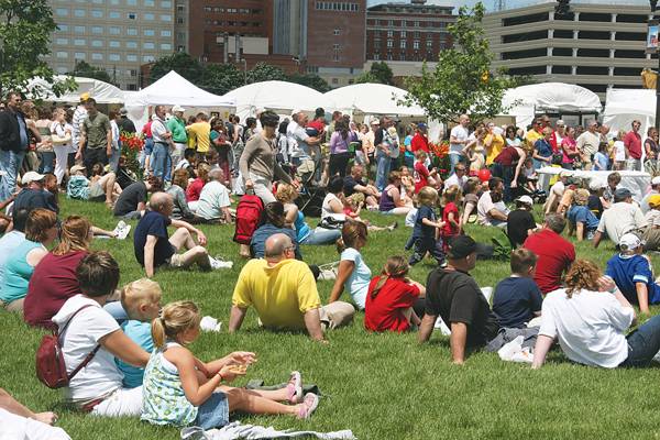 People attending the Des Moines Art Festival take a break on the grass for some entertainment. Photo courtesy: Downtown Events Group