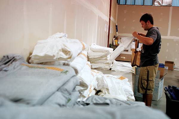 Iowa Sports Foundation intern Ryan Vogt organizes T-shirts Wednesday, July 8, 2009 at the Iowa Sports Foundation on 1421 South Bell Street. There are over 50 sports that need different equipment and Vogt organized each sport's equipment individually so that it would be prepared at the time of the event. Photo illustration: Eloisa Perez-Lozano/Iowa State Daily