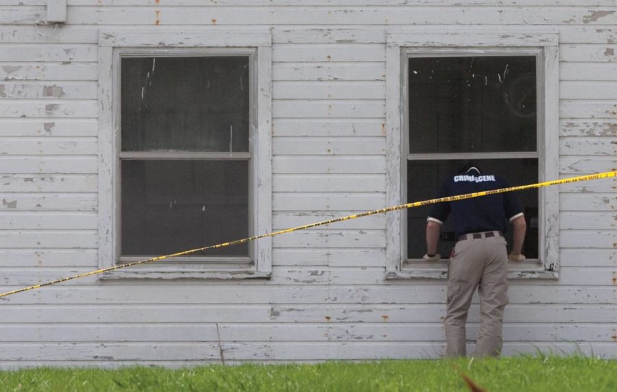 A crime scene investigator looks into a building adjacent to the brick building at the old ISU Dairy farm where a body was discovered by an ISU Police Officer at 8:30 p.m. on Wednesday. Members of the family have said that the body is that of missing ISU student Jon Lacina however Tom Lacina, Jons father, said that the family is waiting for the official results from the medical examiner to confirm it. The property had previously been searched in January. Photo: Rashah McChesney/Iowa State Daily