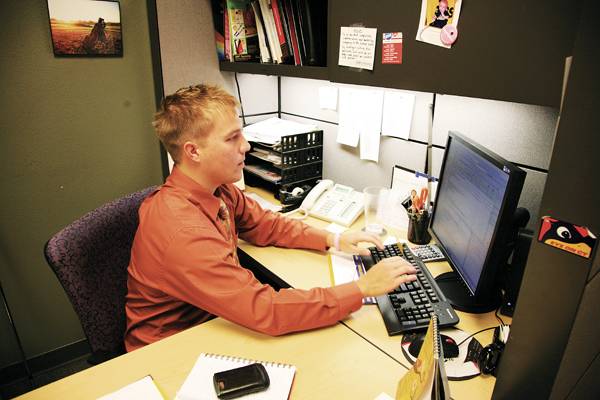 Former ISU golfer Patrick Hall works at his desk in his office at Innova Ideas and Services at 304 Main St. in Ames. Hall, who golfed for Iowa State from 2003-07, said his time as a student-athlete made for a smooth and easy transition from college to the working world. Photo: Zunkai Zhao/Iowa State Daily