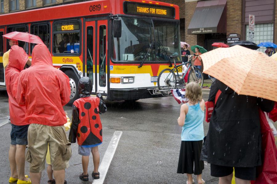 Children wave at a passing CyRide bus Sunday during the parade.  