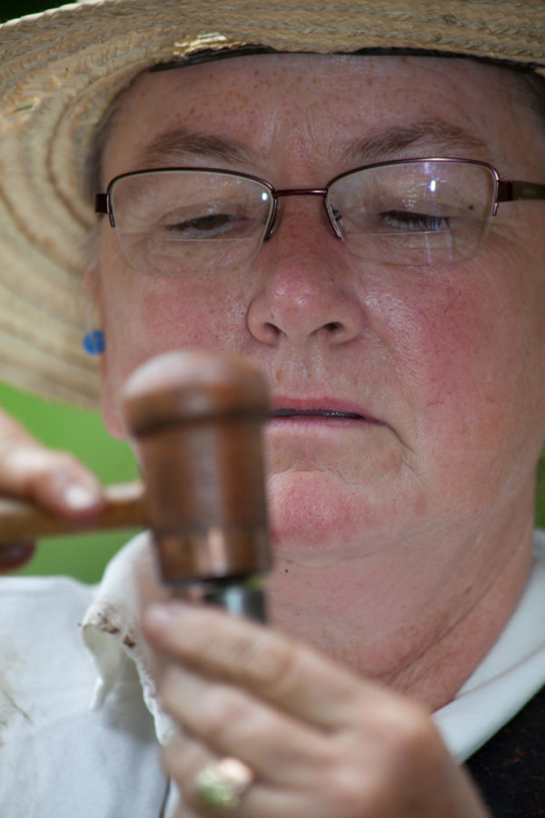 Nancy Clancy uses a hammer to put a musket ball in her 1861 Springfield Musket. Clancy fired a .58 caliber round ball during the womens musket competition Sunday as part of the Iowa Games. Clancy said she has been shooting for 20 years.