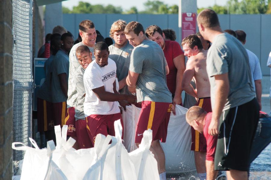 ISU football players move sandbags into position on Wednesday Jacobson Building.