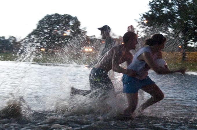 A group of friends play in a flooded area of the Southeast Intramural Fields on Tuesday. Flooding is expected to peak in most areas by midnight Wednesday.
