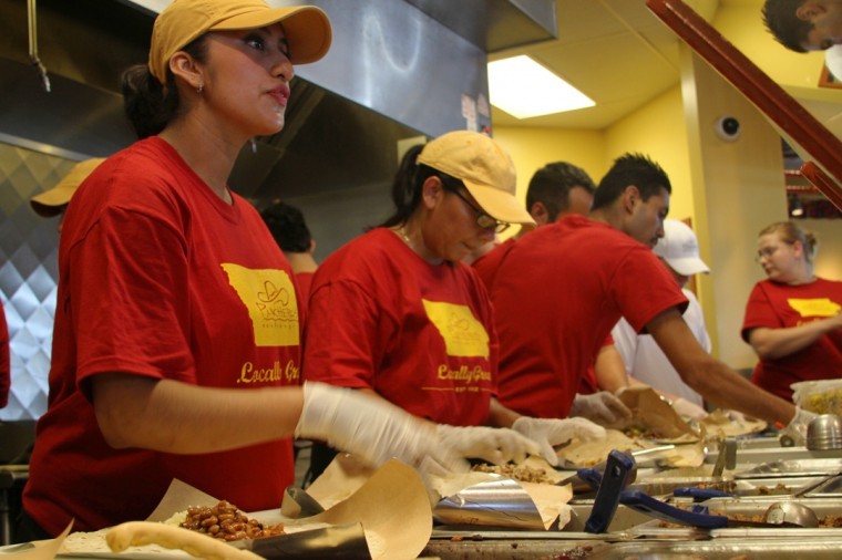 Pancheros employees pack the kitchen to serve the massive line of patrons seeking one dollar burritos on Tuesday, Aug. 24.  The promotion was a competition between locations in Ames and Iowa City to determine whether Cyclone or Hawkeye fans would buy more burritos. Photo: Ryan Damman/Iowa State Daily.