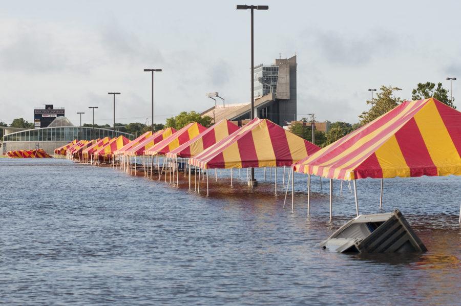 Several tailgating tents have fallen over, with debris floating through the floodwater Monday in the Iowa State Center parking lot.