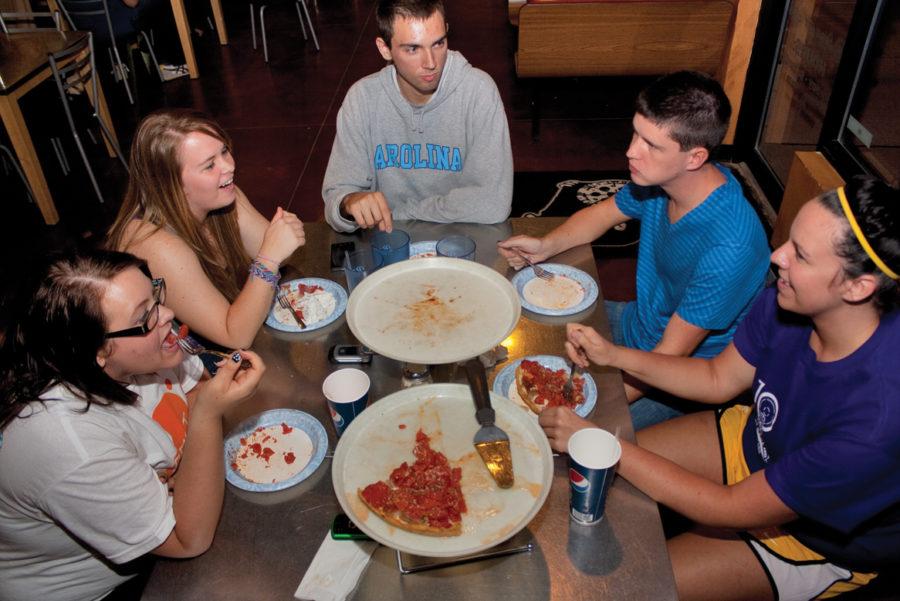 ISU students Heather Anderson, left, junior in agriculture and life sciences education; Jade Byerly, sophomore in meteorology; Clayton Thomas, junior in management information systems; Josh Peterson, junior in graphic design; and Liz McDonough, junior in journalism and mass communication, eat a pizza called Louies Favorite, a Chicago-style pizza with pepperoni, bacon, mushrooms and onions on Friday, Sept. 17 inside Black Market Pizza. One of Black Market Pizzas owners Greg Harvey said he is trying to break the rules of pizza with different flavors and styles.