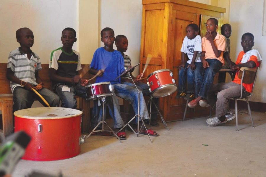 Haitian boys play instruments and sing during the missions summer bible school. About 100 children participated in the program, This and other similar programs are sponsored by the mission will utilize multi-use spaces in the new youth center.