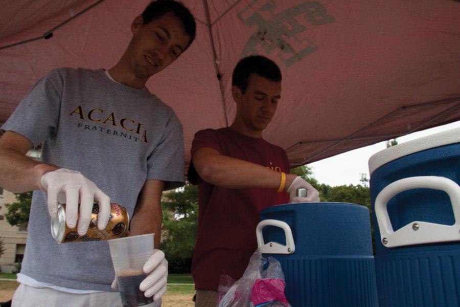Michael Felderman, senior in physics, and Sam Behrens, sophomore in history, make root beer floats Thursday, Sept. 16, on Central Campus as a part of their fraternitys annual philanthropy. Acacia sold root beer floats for $2 to raise money for Pages of Promise.