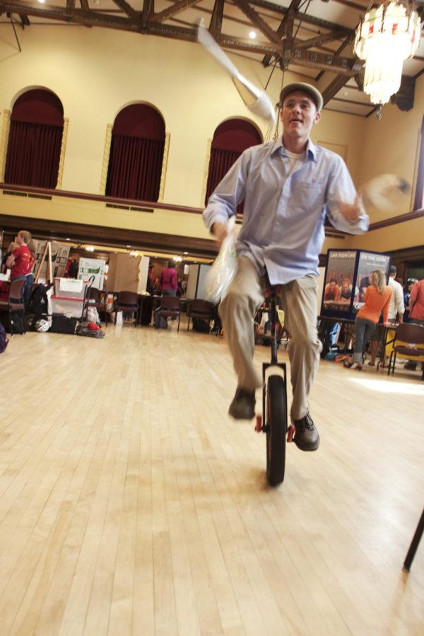 Eric Doll, senior in landscape architecture, juggles while riding a unicycle to show off what the juggling and unicycling club can do Wednesday, Sept. 8, during ClubFest in the Great Hall of the Memorial Union.