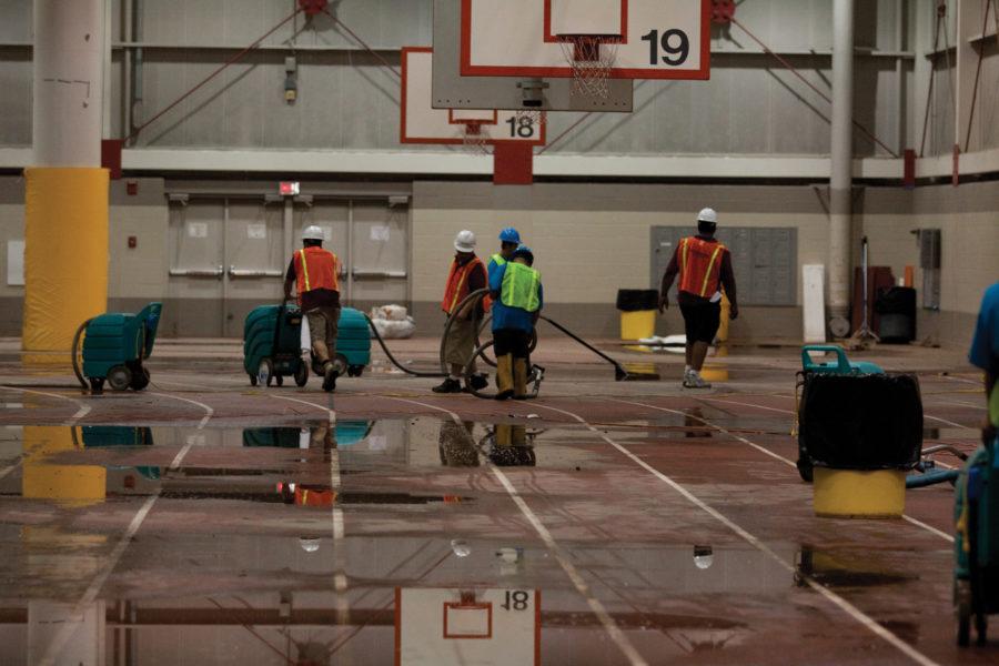 ServiceMaster cleanup crews help to remove the water from the indoor track on Friday, Aug. 13 at the Lied Recreation Athletic Center. Director of Recreational Services Mike Giles is trying to stay positive throughout the cleaning process and will be working with the university to communicate with insurance adjusters.