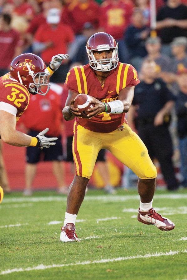 Cyclones quarterback Austen Arnaud hands the ball off to running back Jeff Woody during the game against Northern Illinois on Thursday, Sept. 2. Cyclones defeated the Huskies 27-10. 