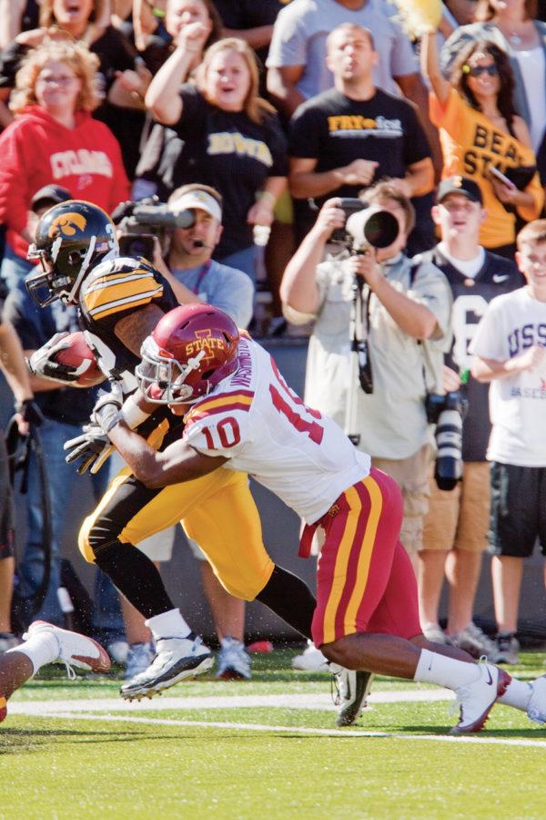 Iowa States defensive back Jacques Washington attempts to take down Iowas running back Adam Robinson right before the Hawkeyes scored a touchdown in the first half.  The Hawkeyes defeated the Cyclones with a score of 35-7.