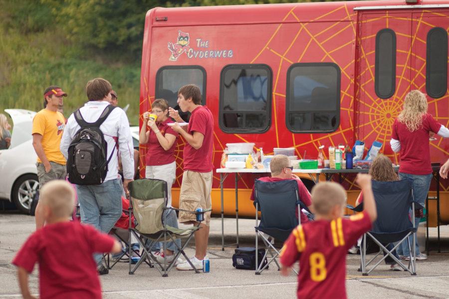 Left to right, Jon Dahlke, of Riceville; Greg Steinberg, sophomore in architecture; Janet Dahlke, of Riceville; and Jared Foss, junior in community and regional planning, enjoy food and drinks outside The Cyderweb bus prior to the start of the first football game of the season on Thursday, Sept. 2. The Cyderweb bus hauls friends from Riceville to Ames on game days. Many of the Riceville Cyclone fans are football season ticket holders and ISU alumni.