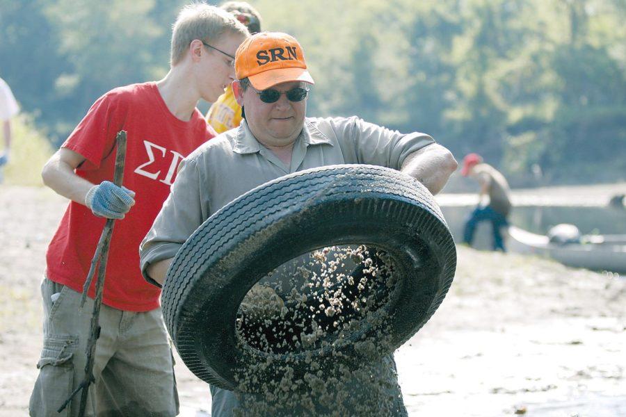 Jim Colbert, founder of the Skunk River Navy, shakes the mud out of a tire before he puts it into a canoe on Saturday September 20, 2008 in the Skunk River.