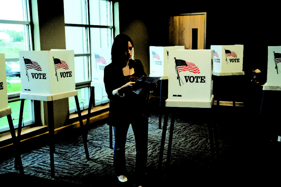 Katlyn Brekke, center, junior in elementary education casts her early mid-term vote Oct. 24 at Cornerstone Church. Mid-term election voting took place Oct. 24 at Cornerstone Church in Ames.