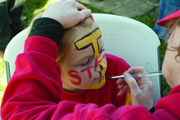 Jenna Fuchs, 7, of Baxter, gets her face painted at the Iowa State-Texas Tech tailgate for Family Weekend Saturday, Oct. 2.