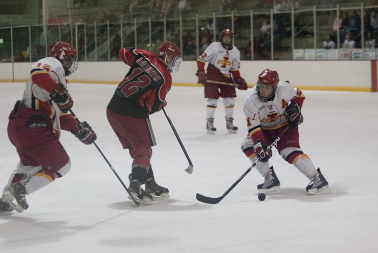 Senior Mike Lebler pushes the puck around Davenports Sean McWhorter during the game Saturday. The Cyclones defeated Davenport University with a score of 5-3.