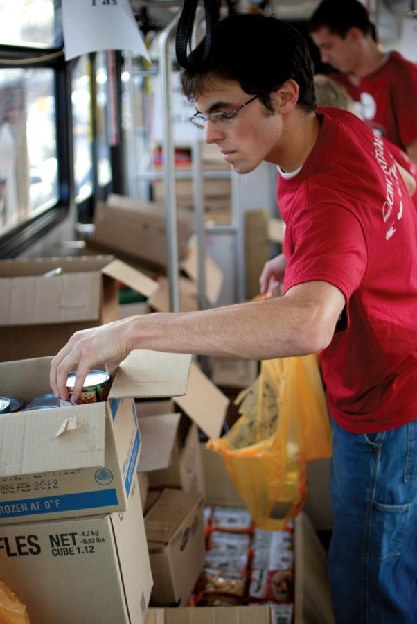 Derek Robison, sophomore in elementary education, helps sort canned vegetables during Saturdays Stuff the Bus event at West Hy-Vee. Volunteers took food and cash donations to benefit the Mid-Iowa Community Action food pantry in Story County.