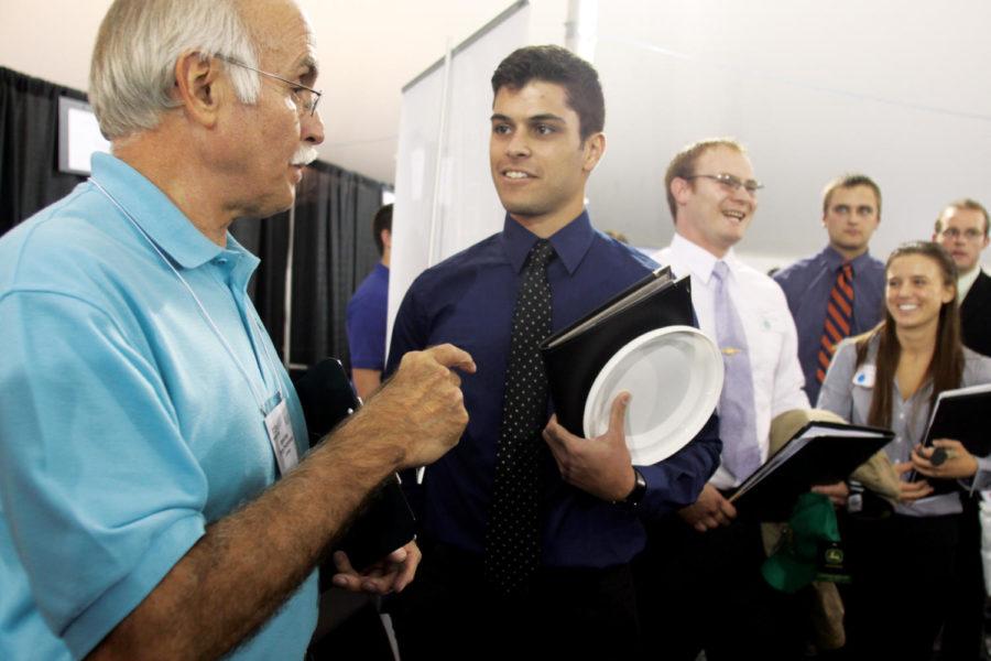Felipe Folhadella, senior in mechanical engineering, meets with a representative from Lennox on Tuesday, Sept. 21 at the engineering career fair. This years career fair was held in tents outside the Iowa State Center due to flood damage inside Hilton Coliseum, the events usual location.