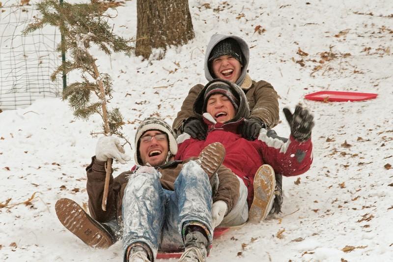 Students enjoy a free day of school in the snow by sledding down the hill behind the Knoll by Richardson Court with dining hall trays. Using trays for sledding is slowly becoming extinct with the Memorial Union being the last dining facility with trays.