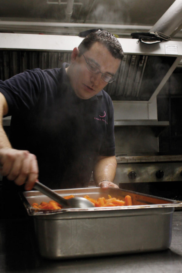 Corey Hansen, head chef at Gamma Phi Beta, prepares cooked carrots on Tuesday, Jan. 12, for the house women. Hansen said it takes 4-5 hours to prepare a meal for the more than 60 women who live in the house. Meals are prepared two times a day, Monday through Friday and at noon on Fridays. The Gamma Phi Beta house is the only greek house that serves locally grown food.