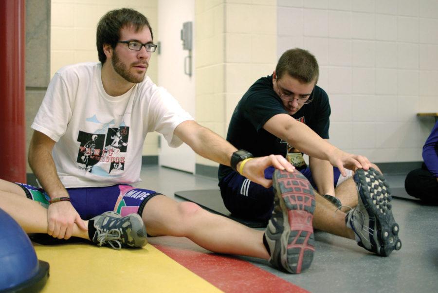 Jesse Leonard, freshman in mechanical engineering, and Ronny Thom, junior in aerospace engineering, stretch out after a strength training session during the CYclo Cross fitness class at Lied Recreational Athletic Center. The Monday night class provides a workout geared toward anyone aiming to improve their fitness levels for summer competitions.