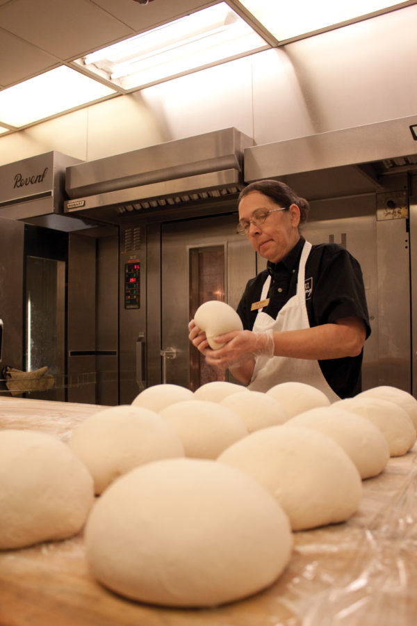 Sue Wells, baker I with Campus Dining Services, shapes a ball of sourdough bread early Thursday, Jan. 27, at the Knapp/Storm Dining Complex. The sourdough bread will be turned into bread bowls that are served with soup at Conversations dining center. Wells and the two or three other bakers work the 11:30 p.m. to 8 a.m. shift to prepare the baked goods ISU students, faculty and staff enjoy at campus dining centers and cafes. I dont mind it, Wells said of the early morning working hours.