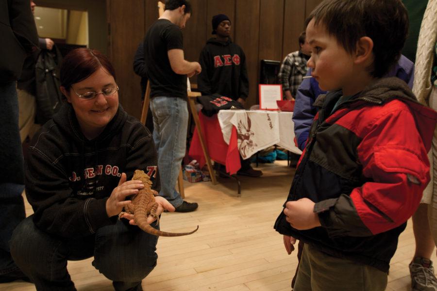 Tina Ward, senior in animal science, shows lizard to people during the ClubFest on Wednesday, Jan. 19, in the Great Hall in Memorial Union. ClubFest gathers all kinds of clubs which students can get involved in to make friends and have fun.