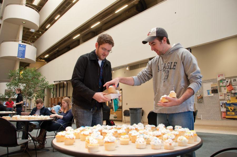 (Left) Chase Kramer and Ryan Gauquie, both graduate in architecture, grab cupcakes from one of the tables, Friday, Feb. 18, 2011, at Design Building. The cupcakes that were put out in the Design Building atrium were part of the TOYS! Studio class project. The class came up with a project that involves people in the College of Design to participate without them actively knowing it. 