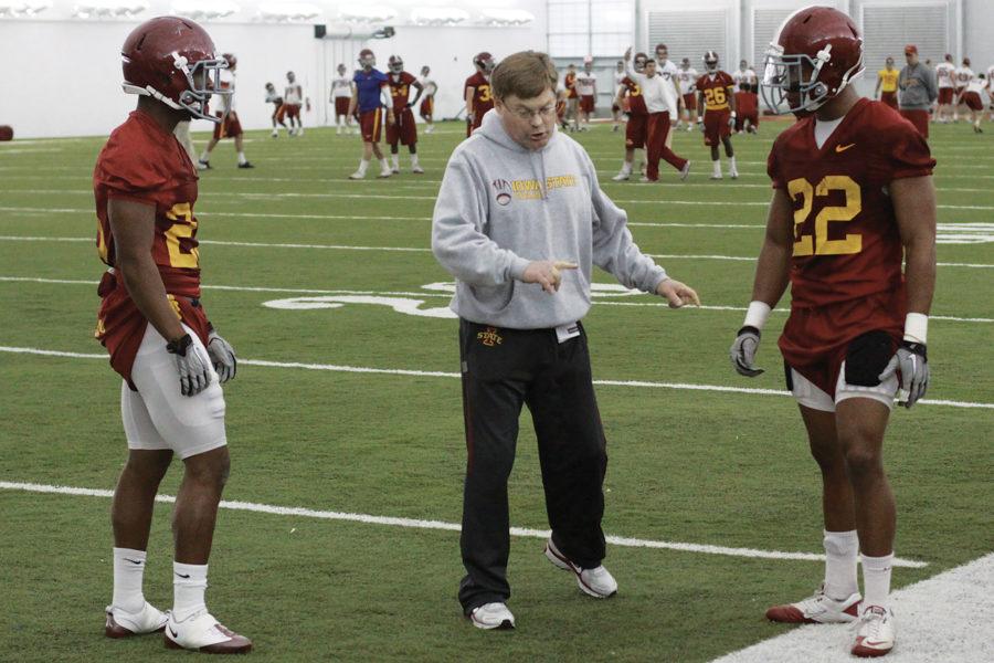 Defensive backs Leonard Johnson, left, and TerRan Benton get instructions from coach Bobby Elliott during spring football practice on Mar. 22, at the Bergstrom Practice Facility.