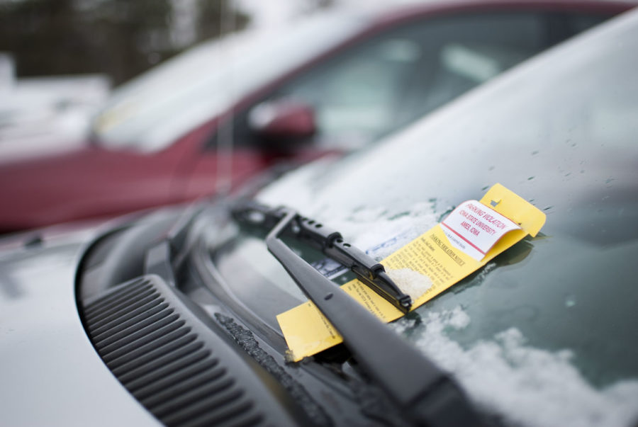A car parked illegally outside Seasons Marketplace sits with a parking ticket in Lot 63. Fines from DPS parking division tickets are used to help subsidize the free route that CyRide runs out to the commuter lot throughout the year.