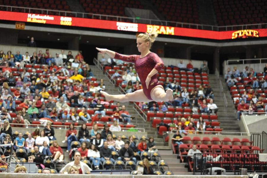 Celine Paulus performs a straddle jump in her beam routine during the meet against the University of Iowa on Friday at Hilton Coliseum. The Cyclones defeated the University of Iowa 196.350 - 195.850.