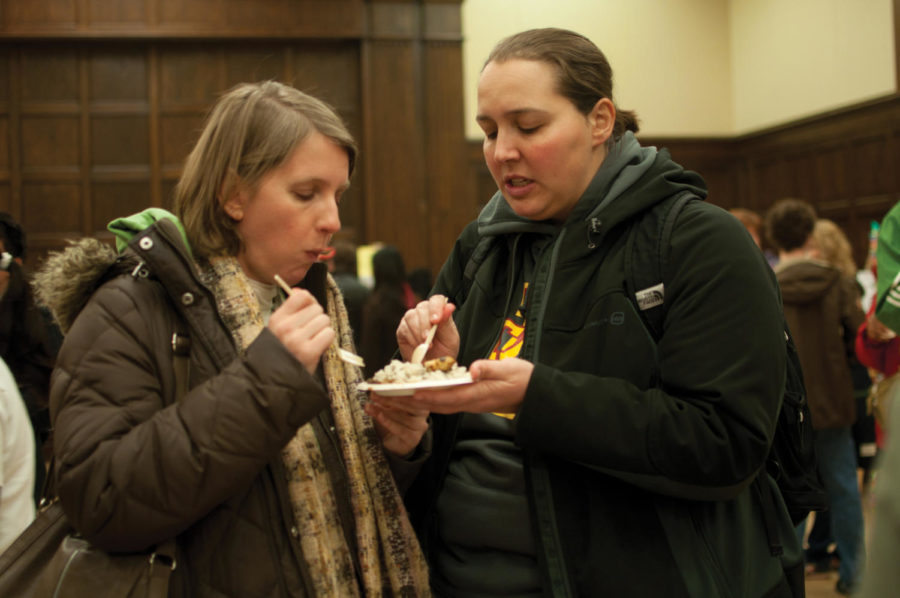 Christina Hill, lecturer in anthropology, and Carrie Drake, program assistant in the athletic department, try the lentil rice by the Iranian Students and Scholars Association during the International Food Fair on Saturday, April 16, in the Great Hall of the Memorial Union.