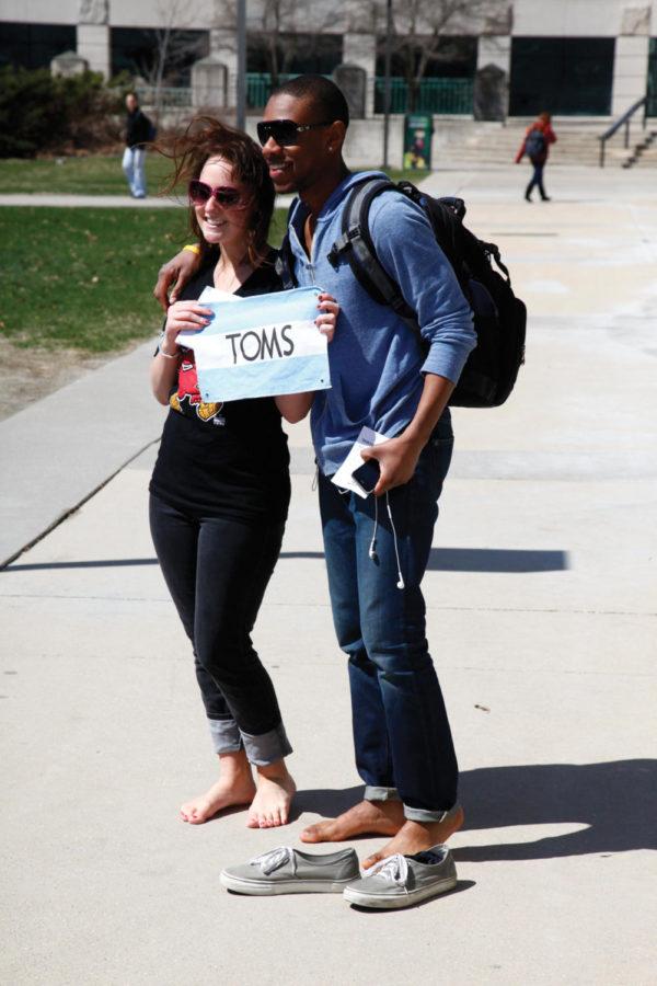 James Sanigular, sophomore in apparel, merchandising and design production, took his shoes off for the cause and poses for a photo with Kaylee Weber. Toms Shoes Awareness Day, students go barefoot to raise awareness for the children around the world that do not have shoes. 