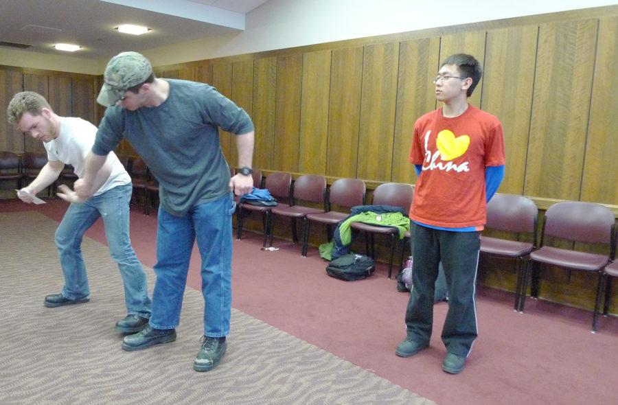 Jingtai Zhou, right, freshman in pre-business, watches Jason Gilbert, freshman in psychology, attack Theodore Westhues, senior in physics, in the Campanile Room at the Memorial Union on Monday. The Hapkido Club has been active in the ISU community providing self-defense demonstrations and seminars, and it teaches ISU student how to escape from dangerous situations. 