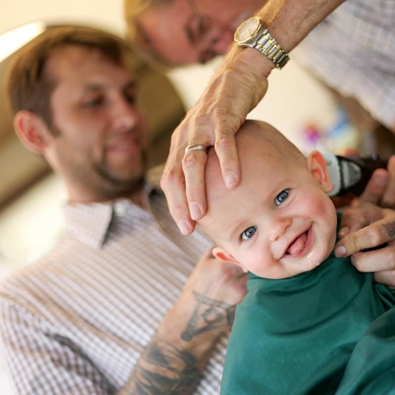 8-month-old Strummer Boone receives his first haircut at Monty’s Barber Shop on Saturday. Monty Brown was celebrating his final day working after more than 40 years as a barber.