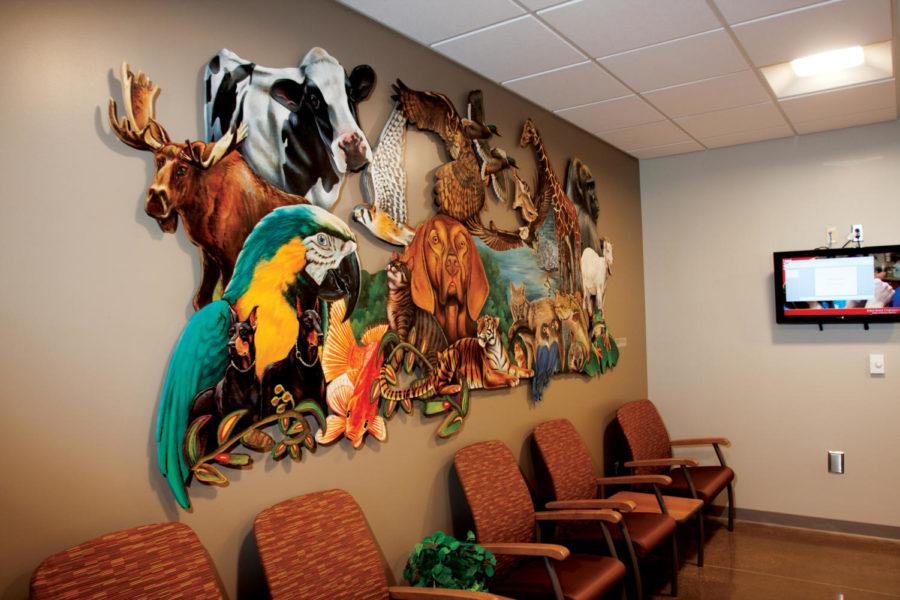 Sarah Grant oversees installation of her art in the small animal
clinic in Vet Med on Aug. 19.
