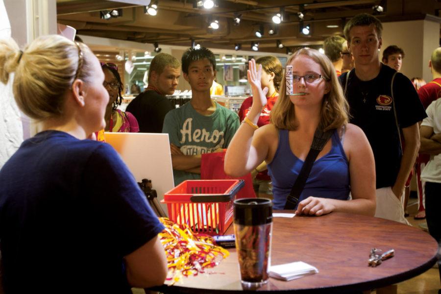 Liza Cooley, freshman in animal science, tries her luck at one
of the Minute to Win It challenges at the University Book Store
Friday night during Late Night at the MU.
