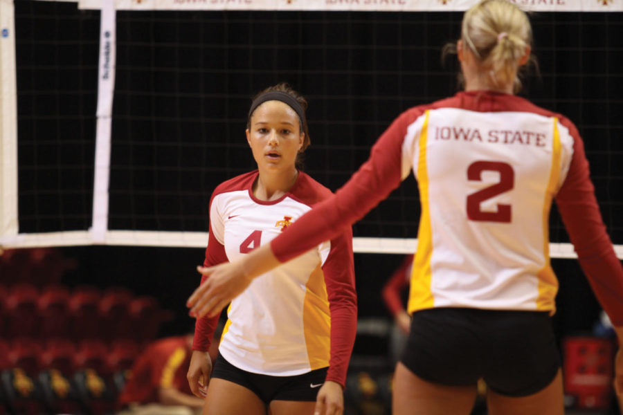 Hannah Willms, right, and Taylor Goetz high five after scoring a
crucial point on Aug. 20 at Hilton Coliseum. 
