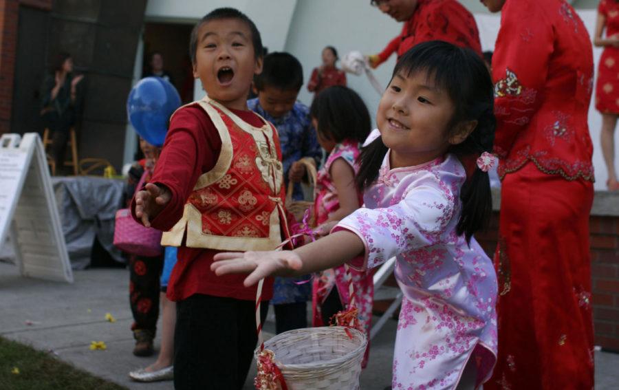 Tanya Fan, of Ames, right, throws candy with a friend during the
FACES of Ames 2011 event on Sept. 24, 2011 at Bandshell Park. The
throwing of candy is supposed to be good luck.
