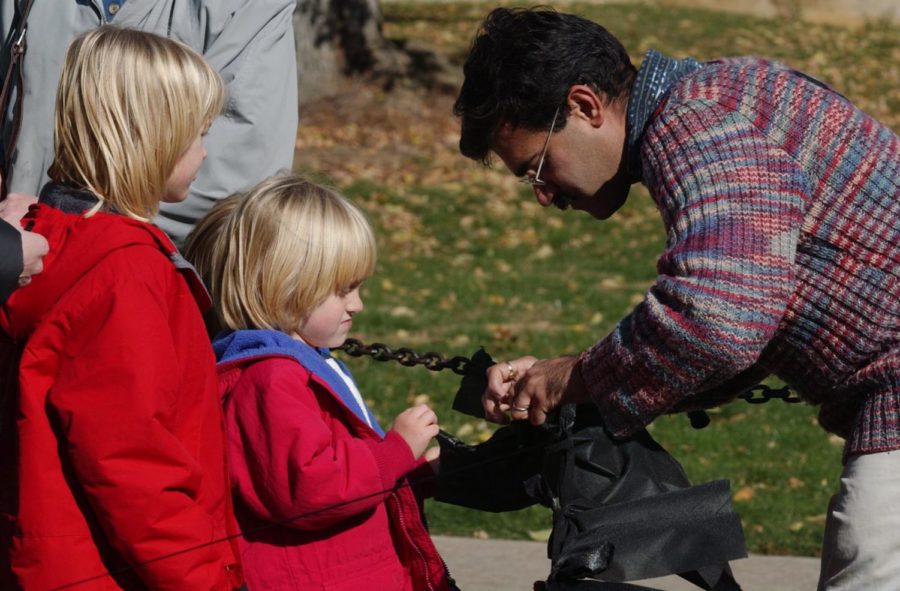 Penn State student Jitesh Malik, right, helps Lauren Giel, 8,
and Emily Giel, center, attach a row of black, fabric panels
Sunday, November 11, 2001, to a memorial to victims of the
September 11 terrorist attacks.
