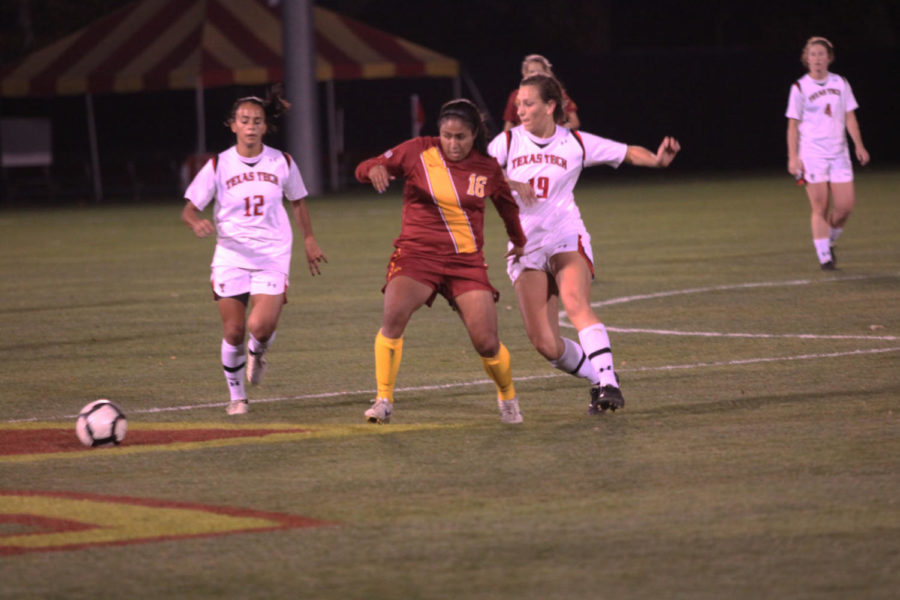 Sophomore forward Jennifer Dominguez holds off a defender as she
receives a pass from a teammate Friday, Oct. 21, at the ISU Soccer
Complex. Iowa State beat the Red Raiders 1-0. Dominguez scored the
only goal of the game in double overtime to secure the victory
