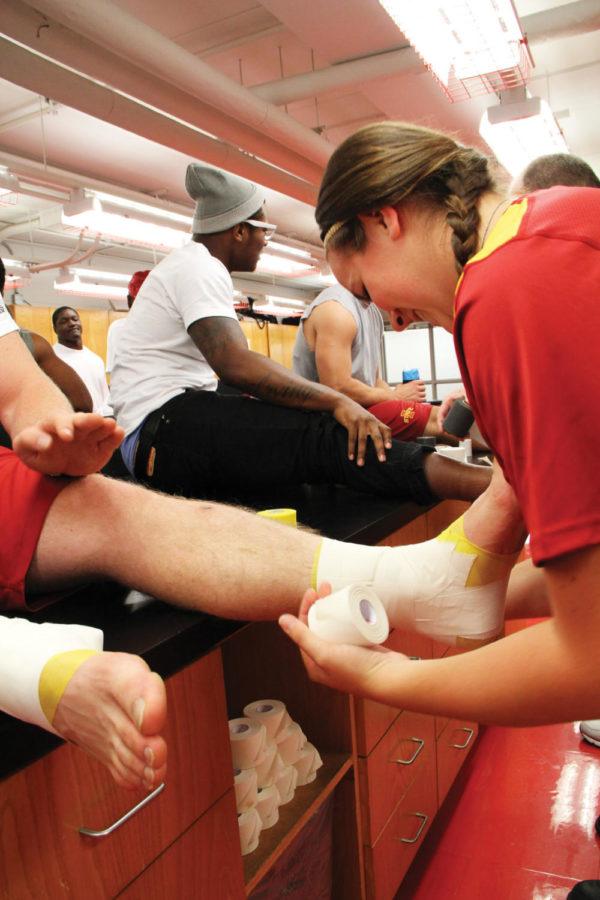 Sami Polson, sophomore in athletic training, wraps up running
back Jeff Woodys Thursday, Oct. 20, at the Jacobson Building.
Students in the athletic training major spend time with athletes
practicing the skills needed for the job. I love it, Polson
said. 
