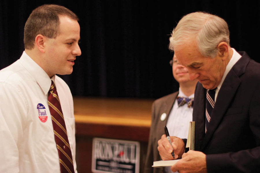 Presidential candidate and U.S. Rep. Ron Paul, R-Texas, signs a copy of his book for Daily columnist Barry Snell at the Story County GOP Chili Supper in Nevada, Iowa, on Tuesday, Sept. 27. The potluck supper served as a platform for several local politicians to campaign in addition to Paul, who gave the keynote speech of the evening.
